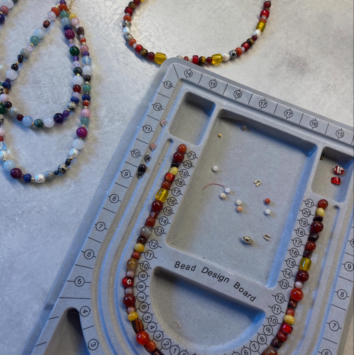 Necklaces taking shape on a bead design board